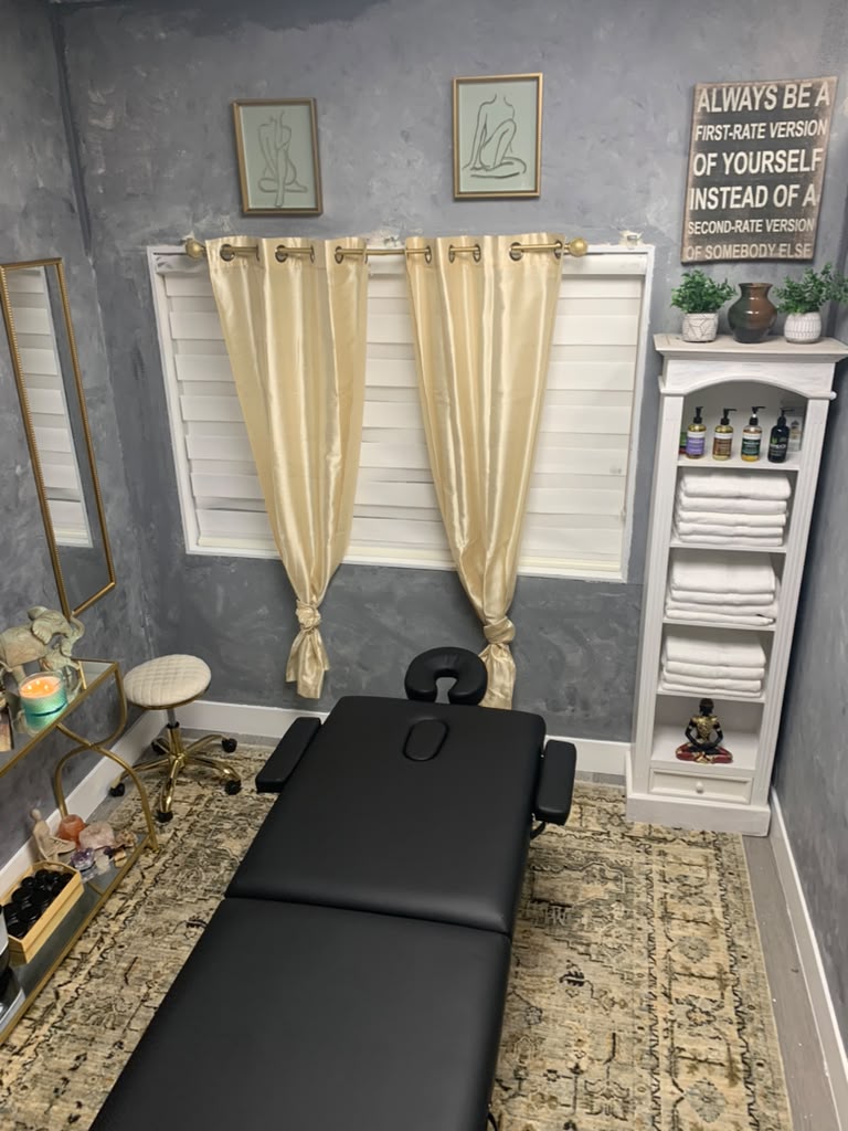 The Paradise Within private massage room in Kent, WA — black massage table, gold silk curtains, fresh white towels and soft candlelight